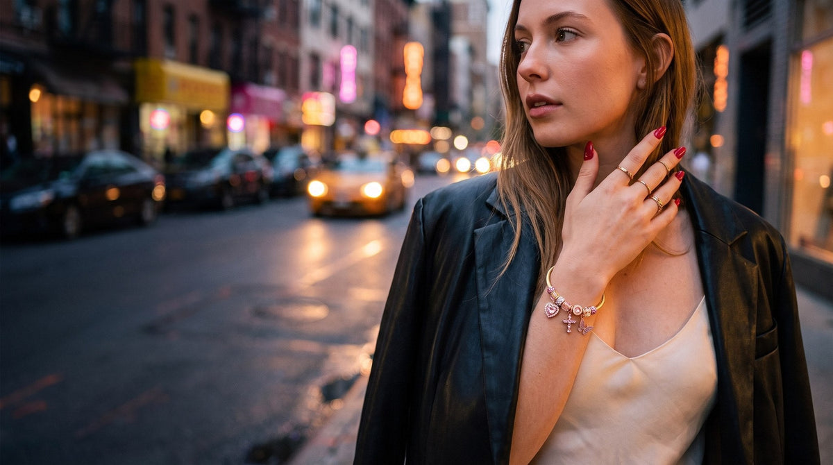 Charm bangle worn on a city street at dusk